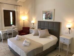 a bedroom with a bed and a desk and a chair at Relais Masseria Serritella in Castellana Grotte