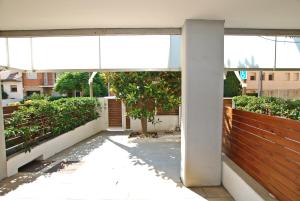a white building with a fence and a tree at Blue fridge apartmen · Blue fridge apartmen · Ideal for couples, near beach and well connected in Vilassar de Mar
