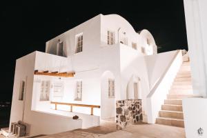 una casa bianca con scale di notte di Ianthe Apartments & Villa a Oia