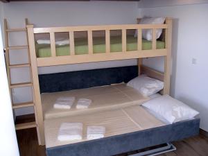 a wooden bunk bed with four pillows on it at Villa Pegasos in Chrysi Ammoudia