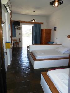 a hotel room with two beds and a table at Diana Apartments in Agia Pelagia