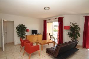 a living room with a couch and chairs and a table at Résidence La Pinède in Le Barcarès