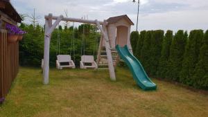 a playground with a slide and two chairs at Julus in Łeba