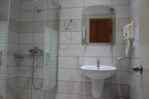 uma casa de banho com um lavatório e um chuveiro em Primavera Hotel em Dassia