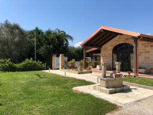 a building with a stone fountain in a yard at Agriturismo Serafina in Otranto