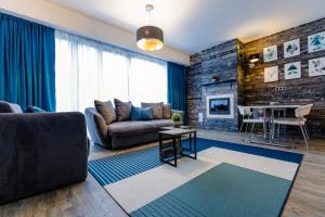 - un salon avec un canapé et une table dans l'établissement Pine Woods Apartment A27 in Silver Mountain, à Poiana Brasov