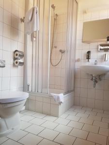 a bathroom with a shower and a toilet and a sink at Hotel-Cafe am Rathaus in Gardelegen