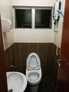 a bathroom with a toilet and a sink and a window at Golden Night Hotel Cameron Highlands in Cameron Highlands