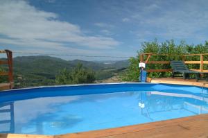 a swimming pool with a chair and a view of the mountains at Casa Elisa in Bibbiena