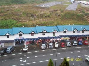 a building with cars parked in a parking lot at Golden Night Hotel Cameron Highlands in Cameron Highlands