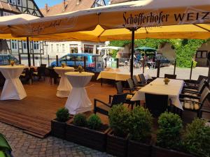 a restaurant with tables and chairs and a yellow umbrella at Hotel-Cafe am Rathaus in Gardelegen