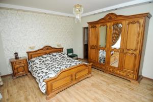 een slaapkamer met een houten bed en een dressoir bij вилла in Tbilisi City