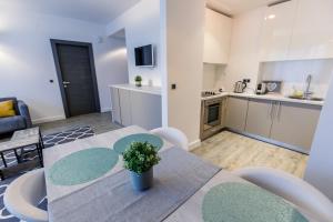 a kitchen and a dining room with a table and chairs at Pine Woods Apartment A28 in Silver Mountain in Poiana Brasov