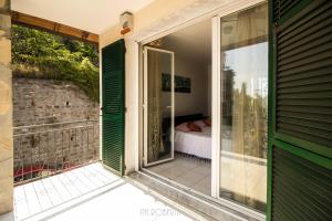 einen Balkon mit grünen Rollläden an einem Haus in der Unterkunft Profumo di Mare free parking included in Sanremo