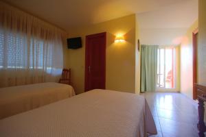 Łóżko lub łóżka w pokoju w obiekcie Hotel La Costera