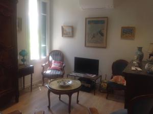 a living room with chairs and a table and a television at Appartement Tout Confort avec Terrasse in Nice