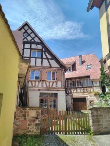 una casa con una valla de madera delante de ella en La Grande Terrine - Gîtes Les Potiers, en Kaysersberg