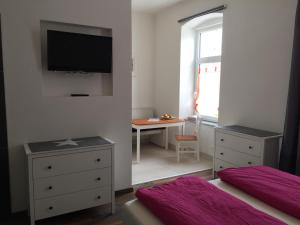 ペルトシャッハ・アム・ヴェルターゼーにあるCandussi-Apartmentsのベッドルーム1室(ベッド1台、壁掛けテレビ付)