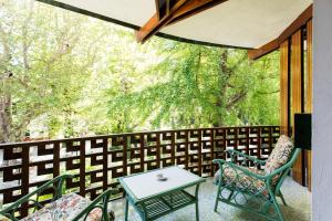 a screened porch with a table and chairs and trees at Residenza d'Epoca Albergo Quattro Fontane in Venice-Lido