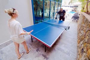 Ein Mann und eine Frau stehen neben einer Tischtennisplatte in der Unterkunft Ramira City Hotel - Adult Only (16+) in Alanya