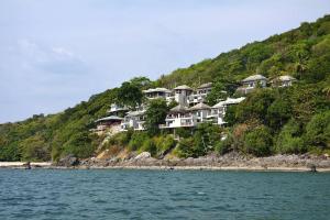 a group of houses on a hill next to the water at Penn Sunset Villa 10 with Shared Pool in Ko Lanta