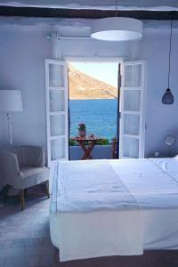 Schlafzimmer mit einem Bett und Meerblick in der Unterkunft La Playa Boutique Apartments in Kalymnos