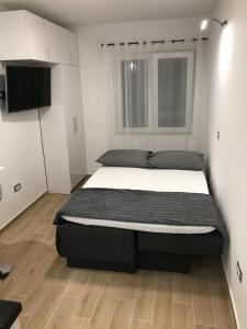 a bedroom with a bed and a flat screen tv at Apartman studio Ganga in Omiš