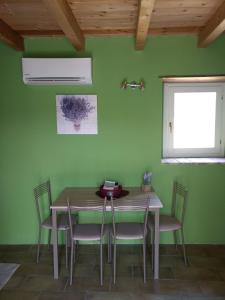 a table and chairs in a room with a green wall at Casetta in Sassi in Varzi
