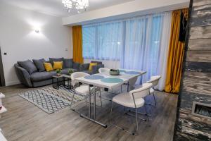 a living room with a table and chairs and a couch at Pine Woods Apartment A43 in Silver Mountain in Poiana Brasov