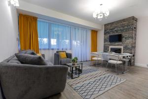 a living room with a couch and a dining room at Pine Woods Apartment A43 in Silver Mountain in Poiana Brasov