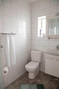 a white bathroom with a toilet and a sink at Private and peaceful one bedroom apartments in Borgarnes