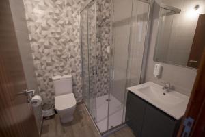 a bathroom with a shower and a toilet and a sink at Alojamento Local do Arado in Bragança