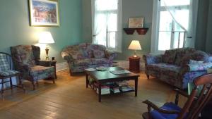 uma sala de estar com duas cadeiras e uma mesa de centro em Aux petits oiseaux CITQO96751 em Baie-Saint-Paul