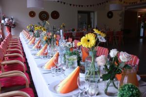 a long table with flowers and vases on it at Hotel Madona in Madona