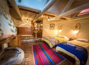 a bedroom with two beds and a rug at Casa de Campo in Cusco