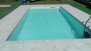 a swimming pool with blue water in a yard at Casa Guaitoli in Terme di Petriolo