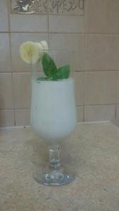 a glass with a flower in it on a counter at Apartamenty Grosik in Krynica Zdrój