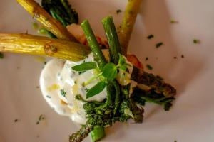 a plate of food with asparagus and a sauce at Tysfjord Hotel in Storjord I Tysfjord
