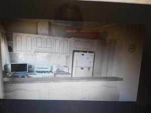 a kitchen with white cabinets and a stove top oven at Glenelg Shores in Adelaide