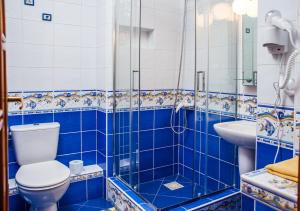 a blue tiled bathroom with a toilet and a sink at Anioł Morski in Władysławowo