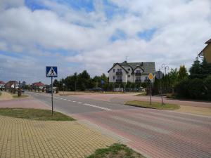 an empty street in a residential neighborhood with houses at JODA Pokoje Goscinne in Rewal