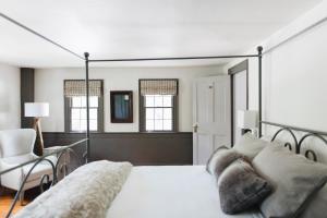 a bedroom with a large bed and a chair at Squire Tarbox Inn in Westport