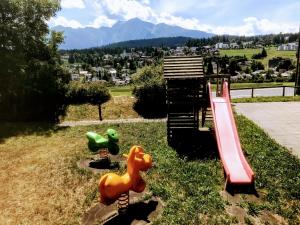 un parque infantil con tobogán y 2 equipos de juego en T3 Alpenhotel Flims, en Flims