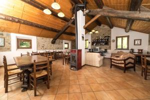 ein Wohnzimmer mit Holzdecken sowie Tischen und Stühlen in der Unterkunft Agriturismo Carovane in Compiano
