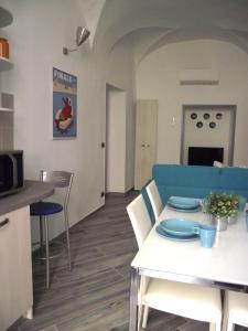 cocina y comedor con sofá azul y mesa en Casa Bartelli, en Finale Ligure