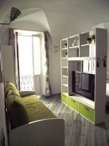 sala de estar con sofá y TV en una habitación en Casa Bartelli, en Finale Ligure