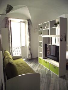 a living room with a couch and a tv in a room at Casa Bartelli in Finale Ligure