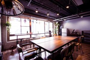 une salle à manger avec une grande table et des chaises en bois dans l'établissement A.R.T., à Kaohsiung