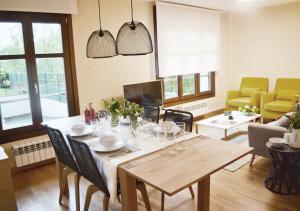 sala de estar con mesa de madera y sillas en Apartamentos Venuntiempo, en Llanes