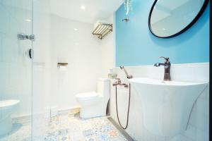 a bathroom with a sink and a toilet and a mirror at A.R.T. in Kaohsiung